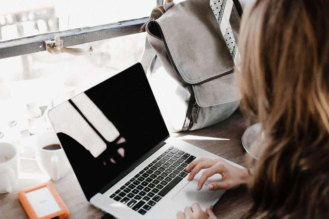 Photograph of woman working at a laptop to illustrate productivity hacks