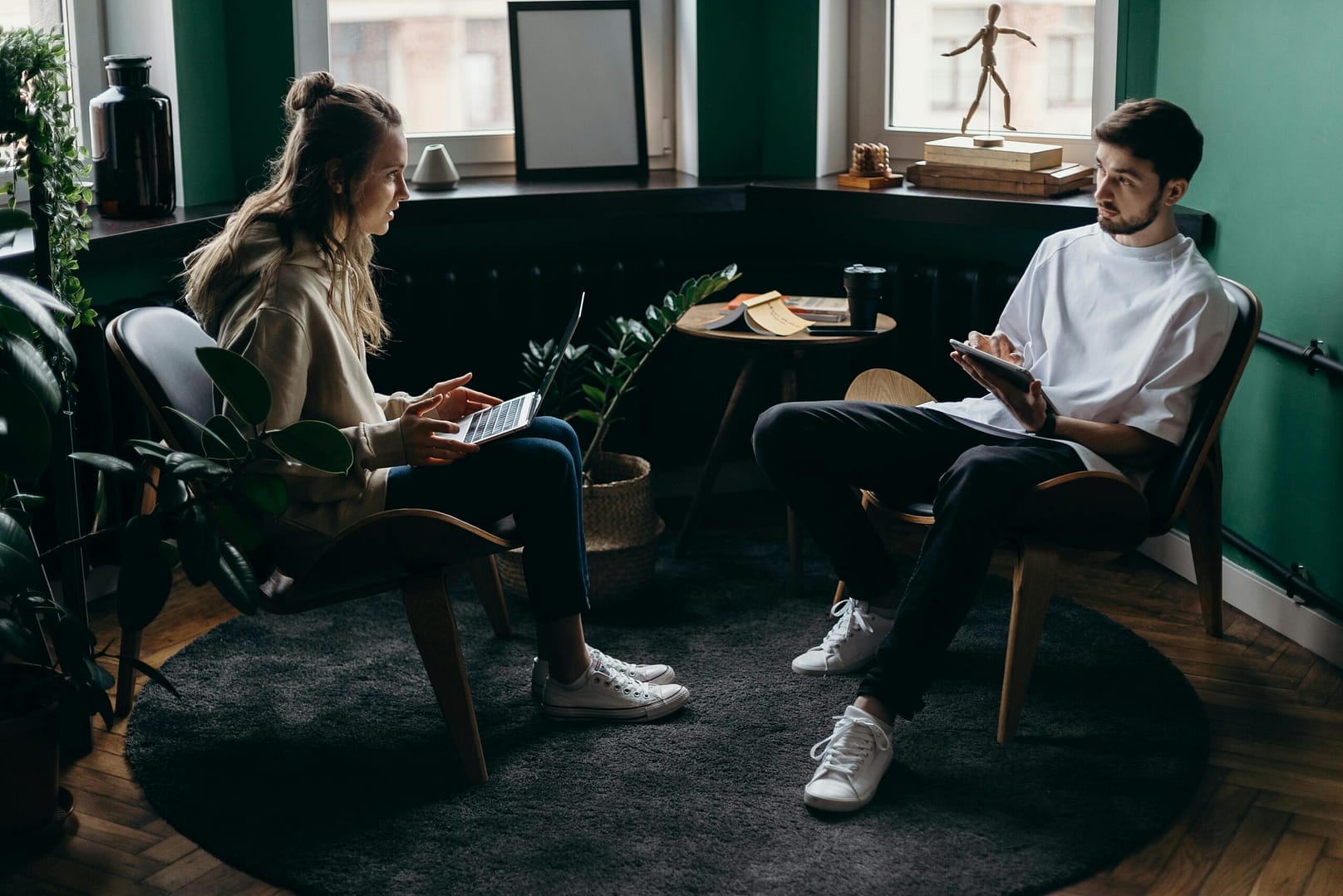 photograph of couple sitting in an adversarial position using technology, to illustrate Online vs Offline Software