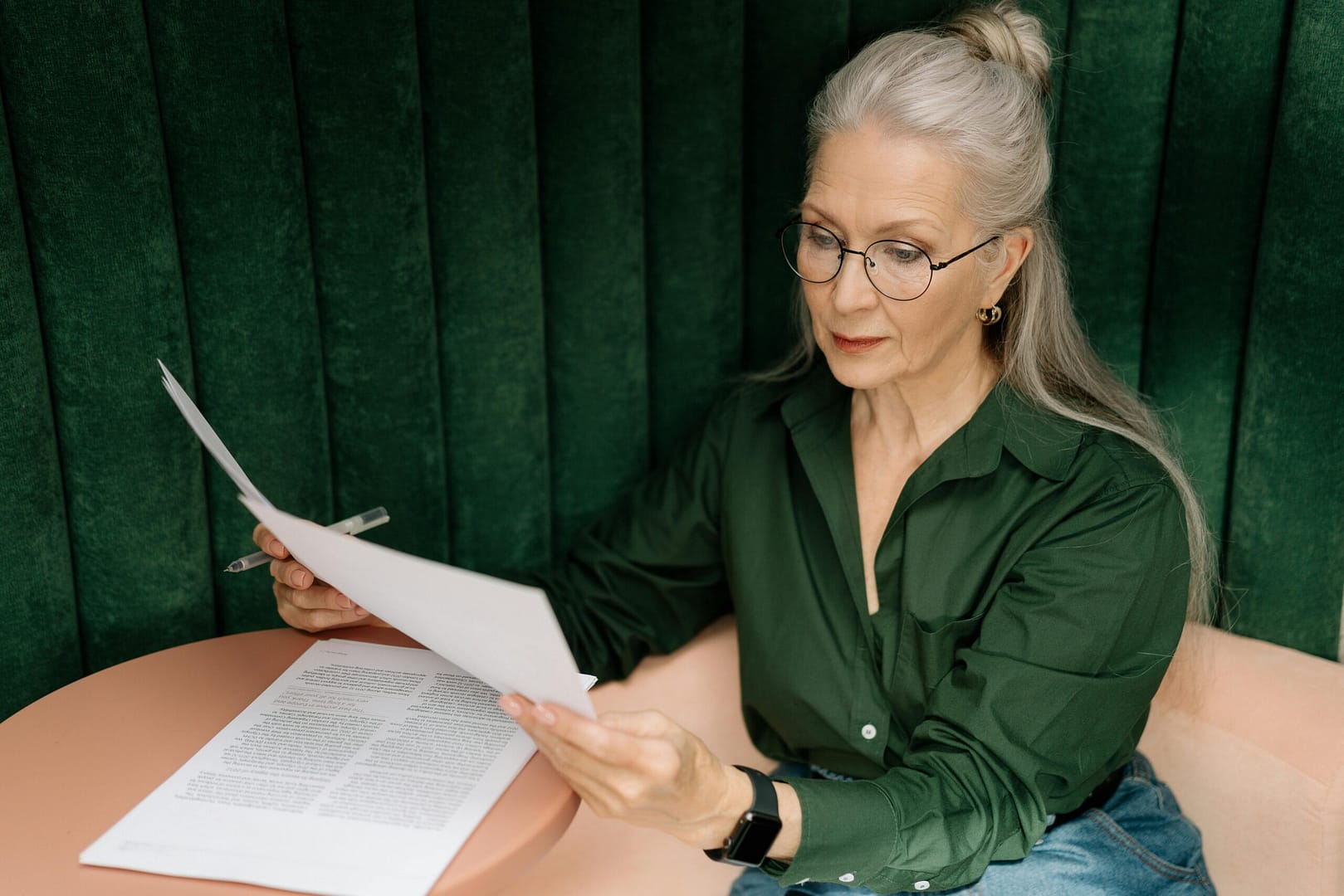 photograph of middle-aged women sitting at a desk reading papers to illustrate the challenges faced by a litigant in person