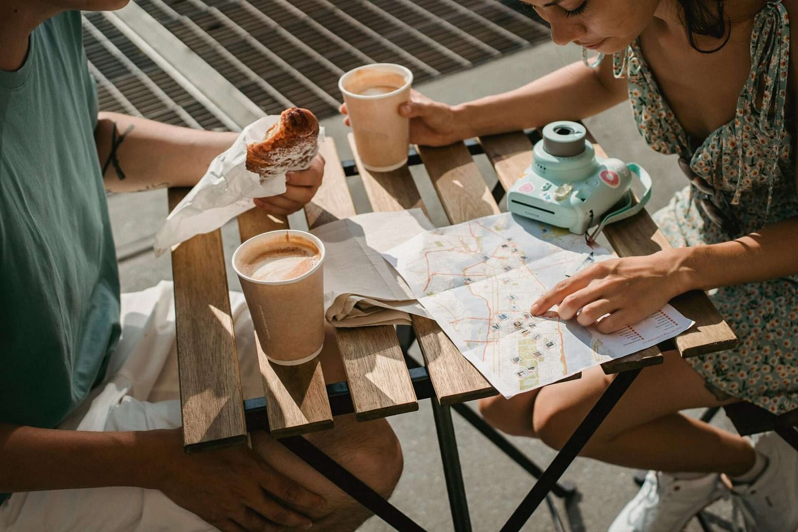 A photograph of a couple sitting having coffee and looking at a map